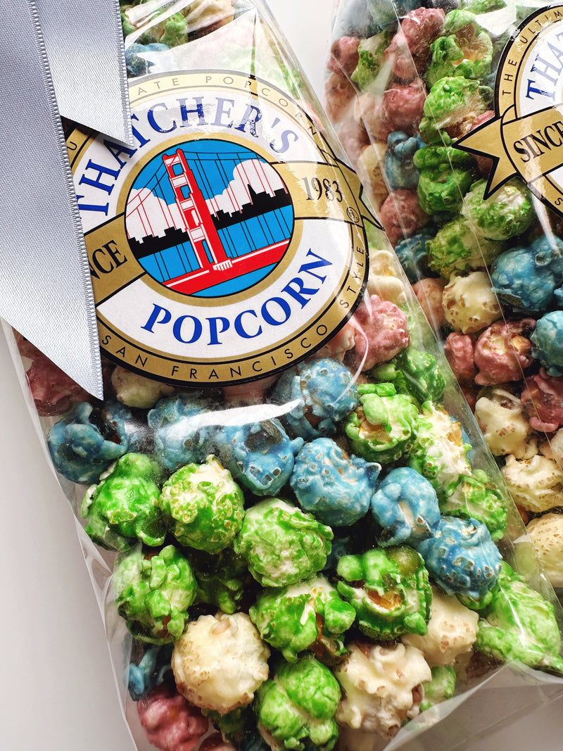 Thatcher's Gourmet Popcorn Spring Mix Popcorn 8oz bag with colorful, mixed-flavored popcorn in a clear bag.