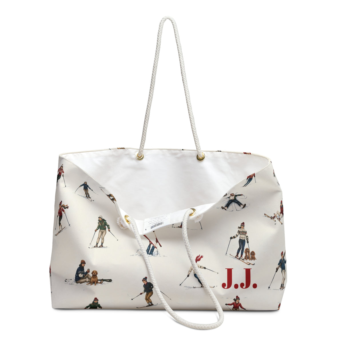 An off-white canvas tote bag with a white rope handle, featuring a vintage-style print of skiers and a red 'J.J.' monogram.