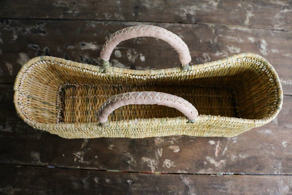 Woven basket with handles on a wooden surface