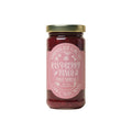 Jar of raspberry fruit spread with a pink label on a white background from Marmalade Grove in Ojai California.