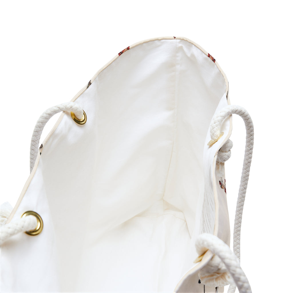 White drawstring bag with gold accents on a white background