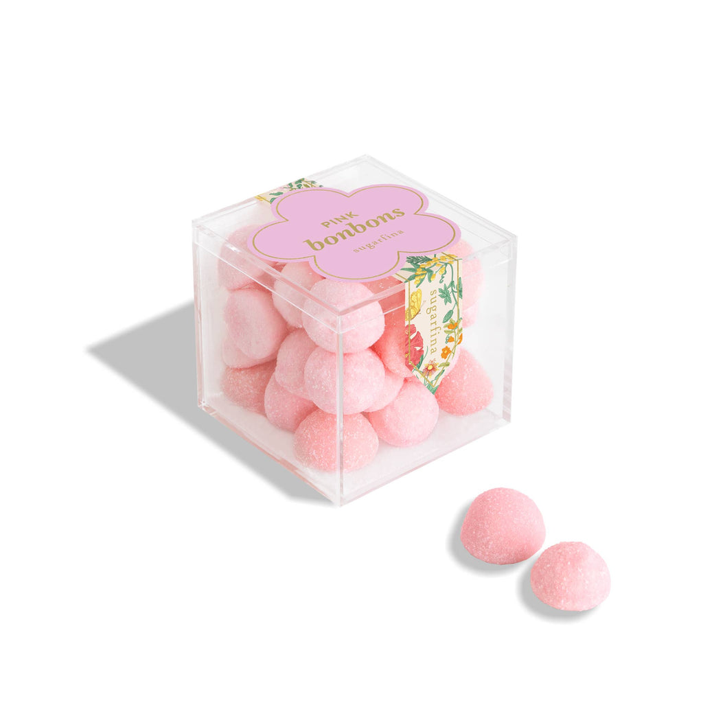 Small pink Sugarfina bonbons in a clear glass jar, showcasing colorful chocolate and candy confections.