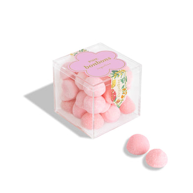 Small pink Sugarfina bonbons in a clear glass jar, showcasing colorful chocolate and candy confections.
