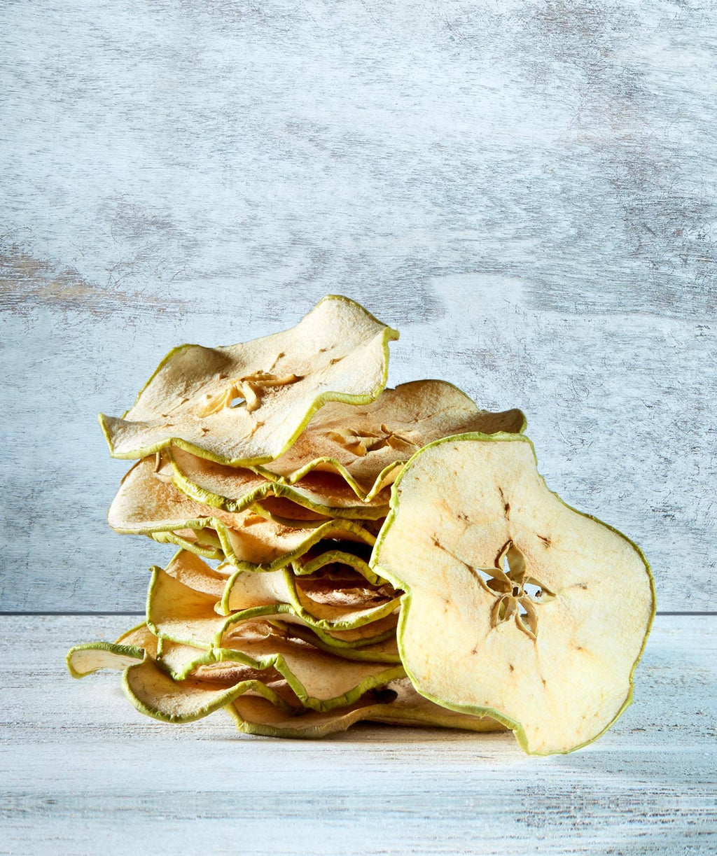 Crispy Apple Slices snack by Dardimans California Crisps, showing golden dried apple slices arranged on a white background.