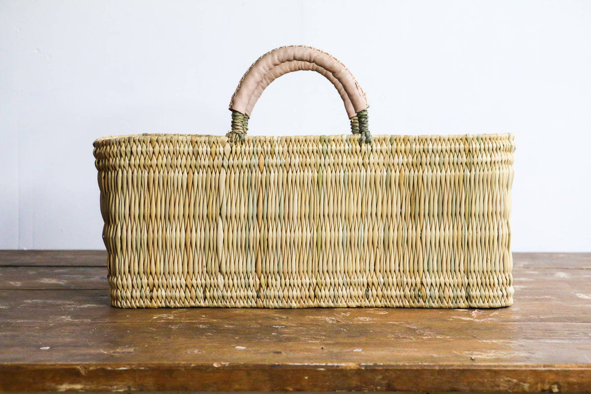 Woven basket with a handle on a wooden surface
