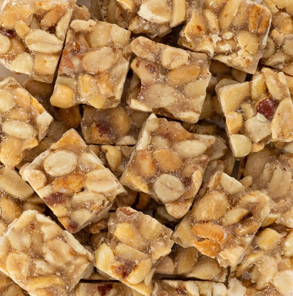 Belmont Peanuts holiday peanut brittle squares, golden and crunchy snack with chunks of peanuts in caramelized brittle.