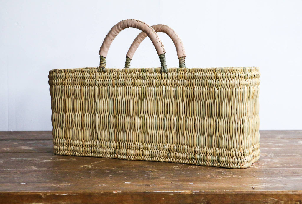 Woven basket with handles on a wooden surface