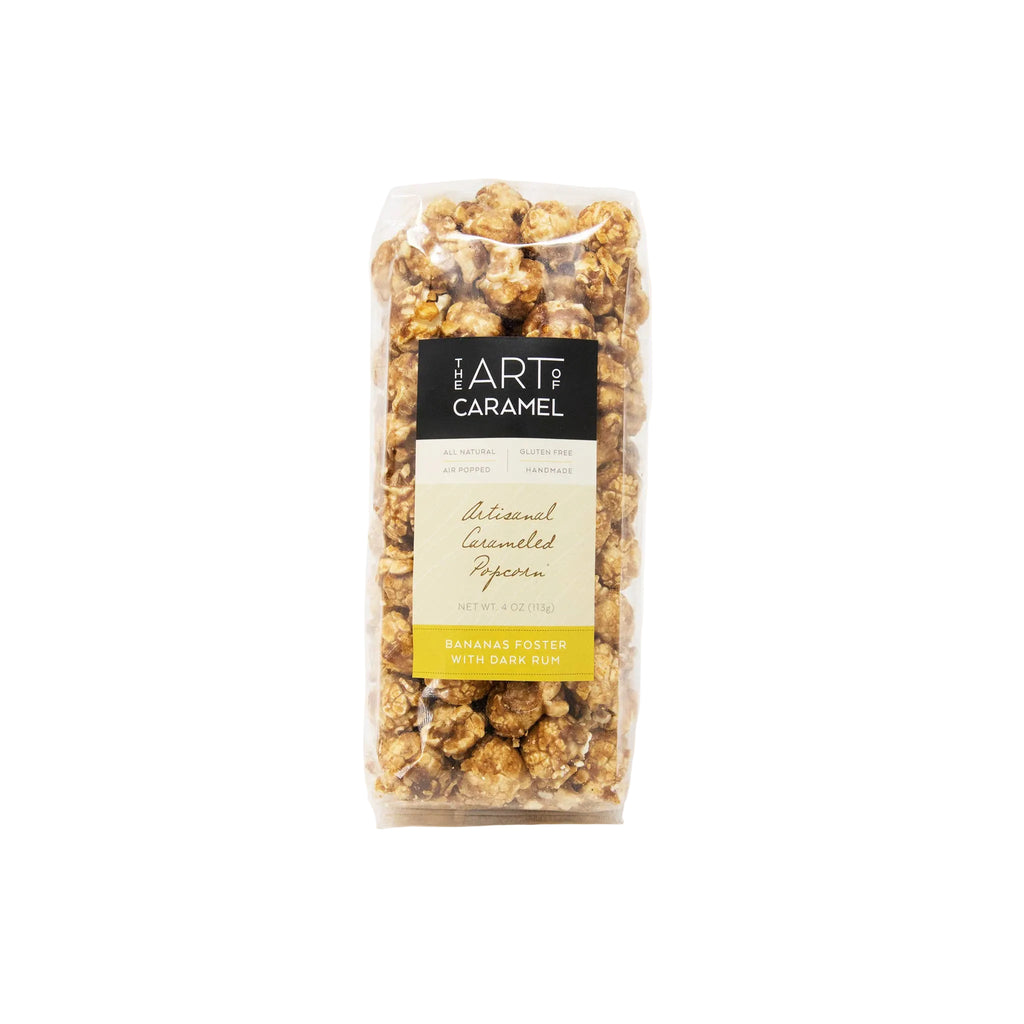 A clear plastic bag of Art of Caramel Natural Caramelized Popcorn, Banana Fheet with Dark Rum, on a clean white background.