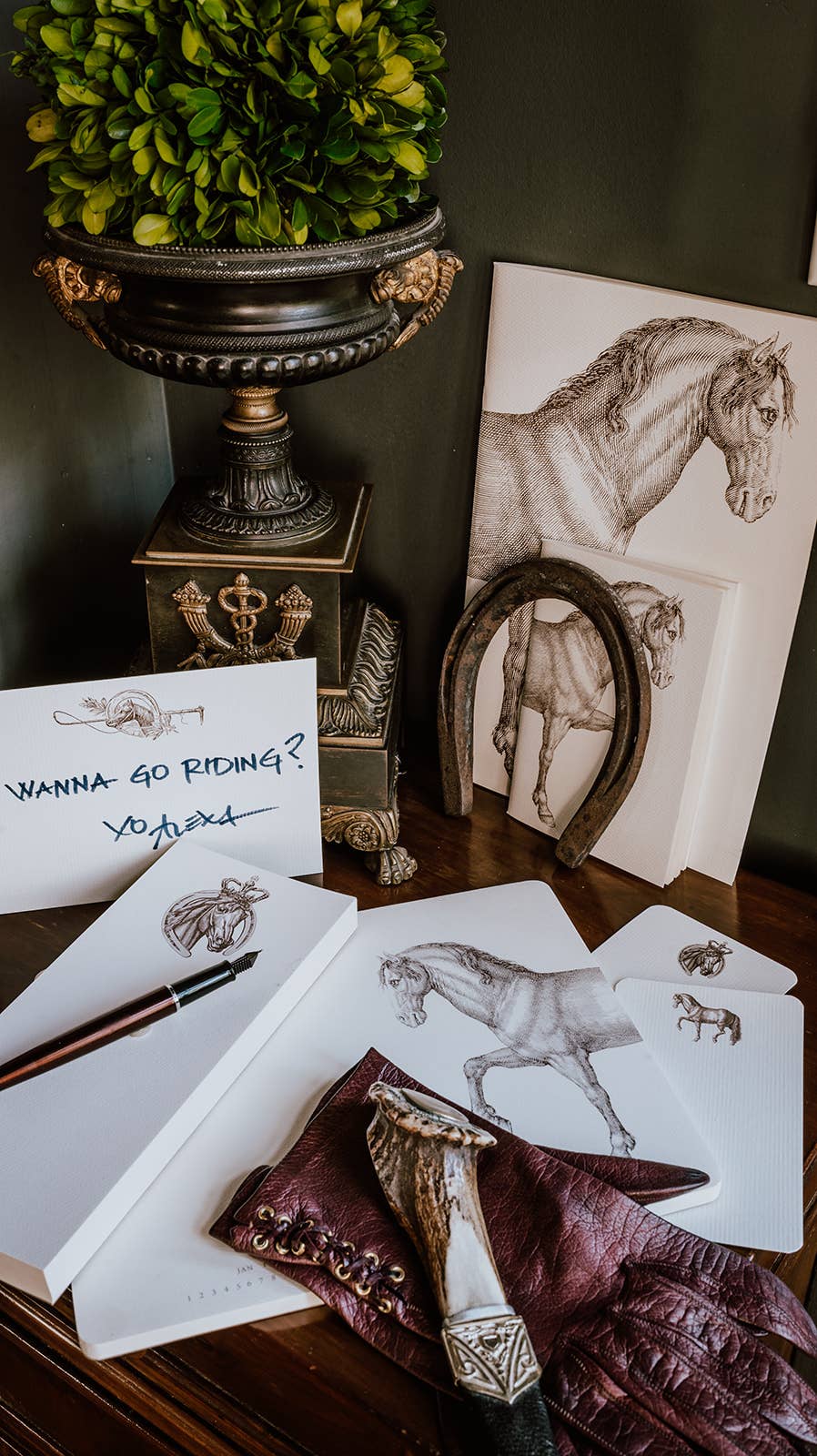 Stationery set with horse-themed items on a wooden surface