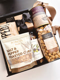 Black and tan gift box from Poppins & Post featuring a stylish, elegant packaging with assorted treats inside.