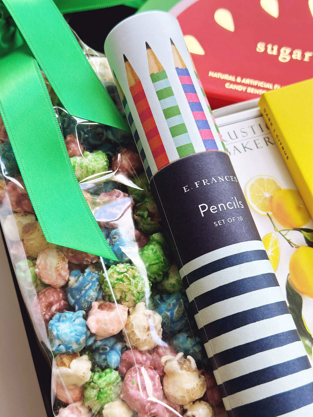 Tube of pencils with striped design next to a box of candy