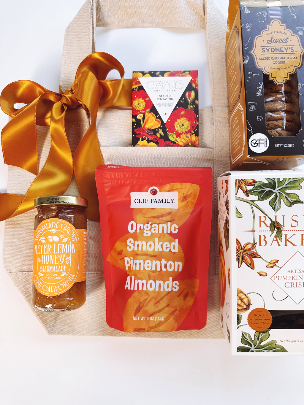 A curated gift box with California products featuring a jar of jam, a bag of Clif Family Organic Smoked Pimenton Almonds, Chocolate Bar and Cookies
