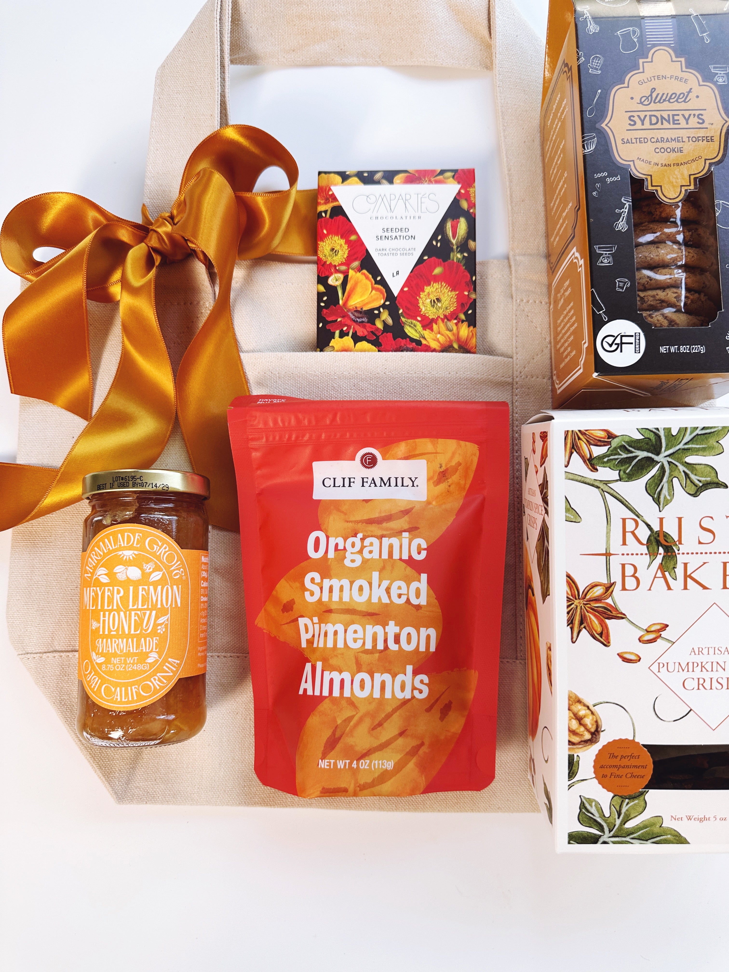 A curated gift box with California products featuring a jar of jam, a bag of Clif Family Organic Smoked Pimenton Almonds, Chocolate Bar and Cookies
