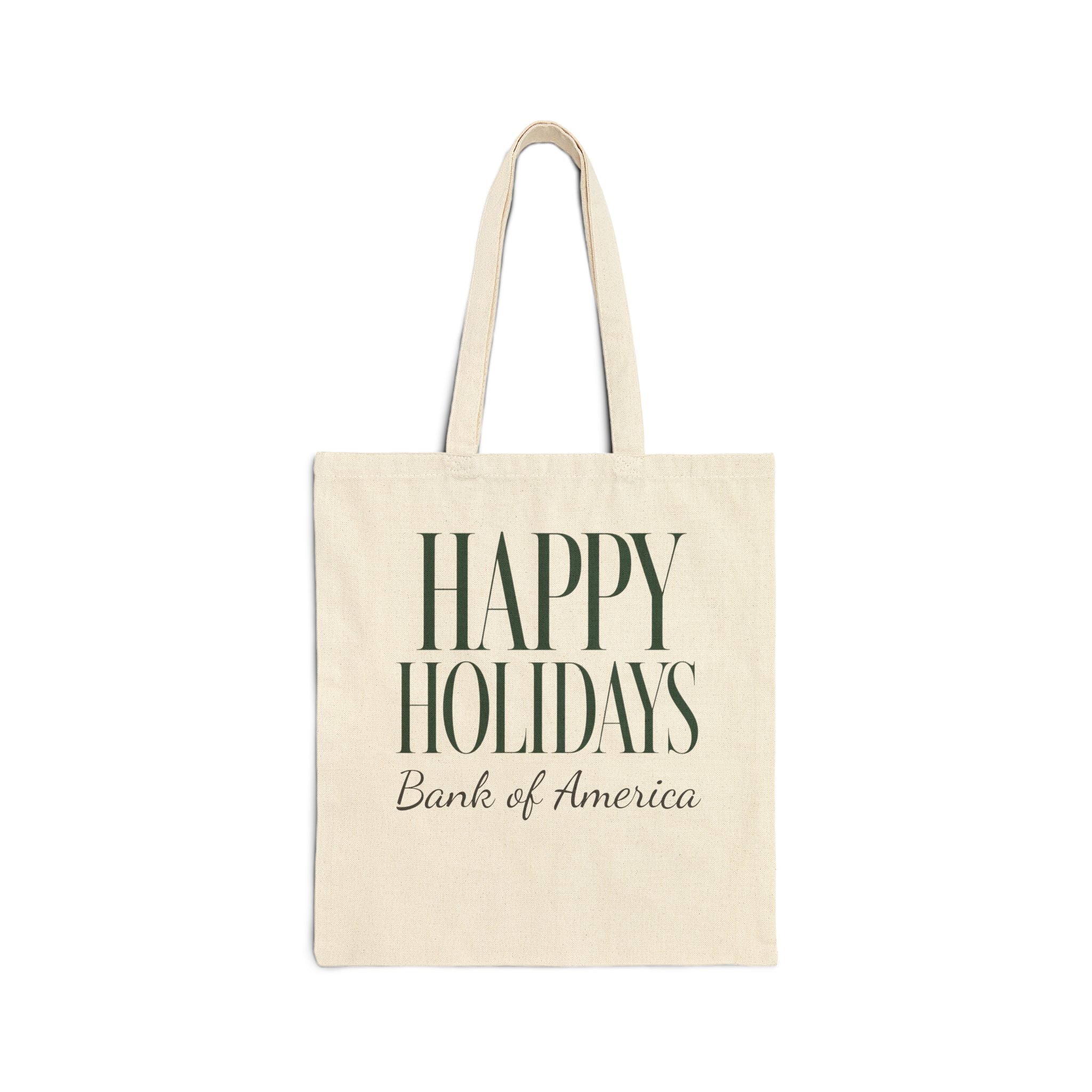 An off-white canvas tote bag with long handles, featuring the text 'HAPPY HOLIDAYS' in dark green serif letters and 'Bank of America' in dark brown script underneath, shown on a plain white background.
