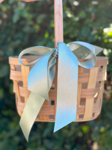 Wooden basket with a decorative ribbon against a blurred green background