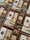 A gift box filled with an assortment of holiday treats.  Rustic Bakery Gingerbread, the Art of Caramel, Carmel Popcorn, White Hot Chocolate and Marshmallows.