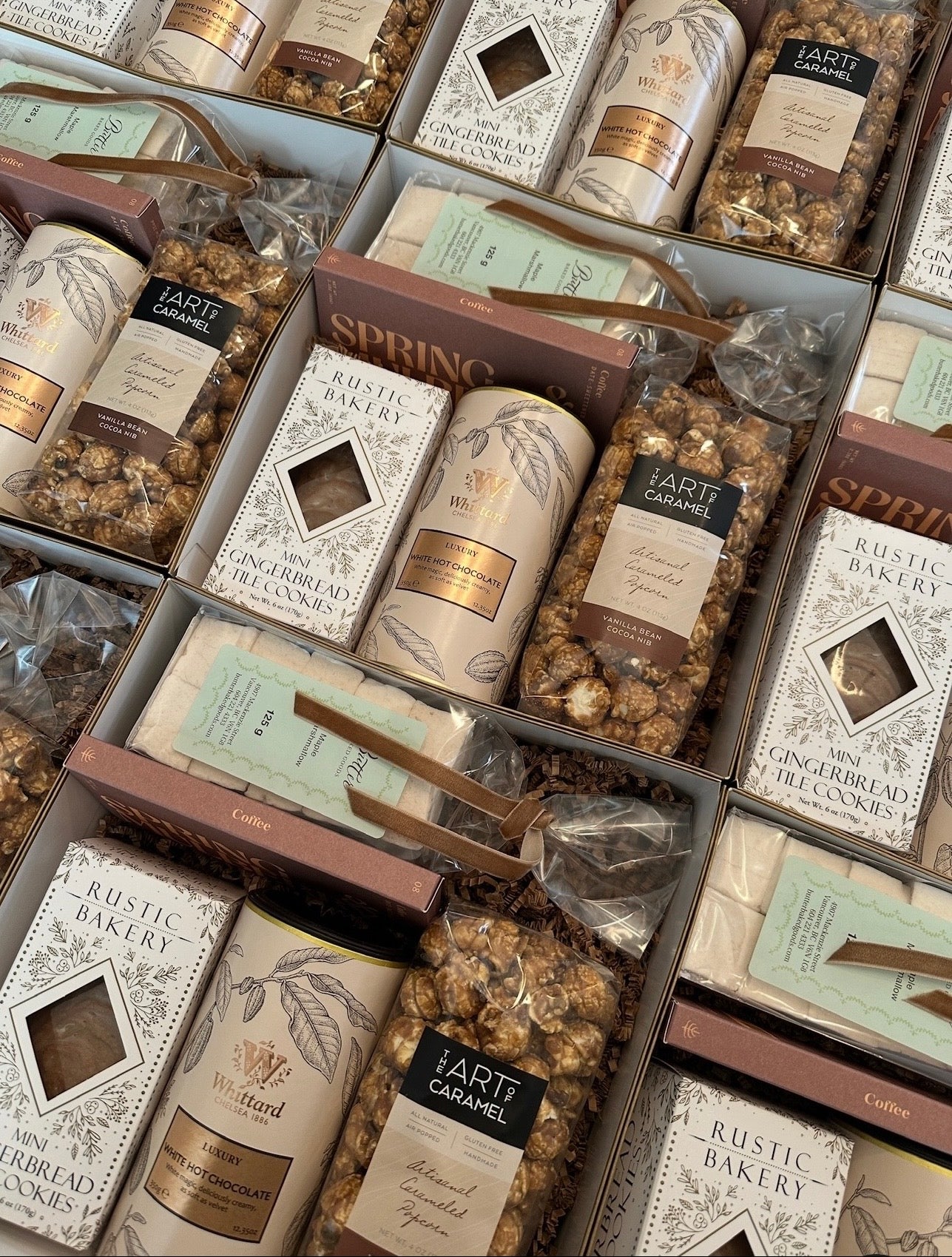 A gift box filled with an assortment of holiday treats.  Rustic Bakery Gingerbread, the Art of Caramel, Carmel Popcorn, White Hot Chocolate and Marshmallows.