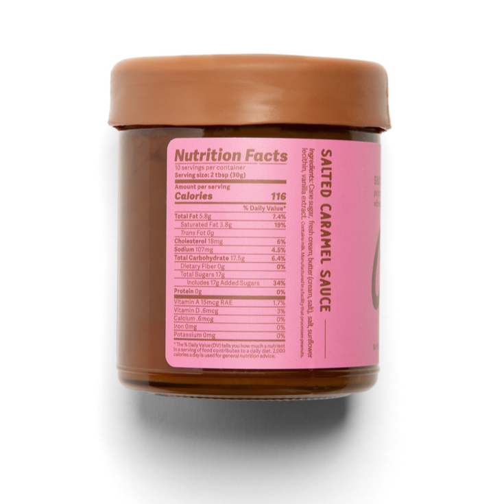 Jar of salted caramel sauce with pink label showing nutrition facts on a white background