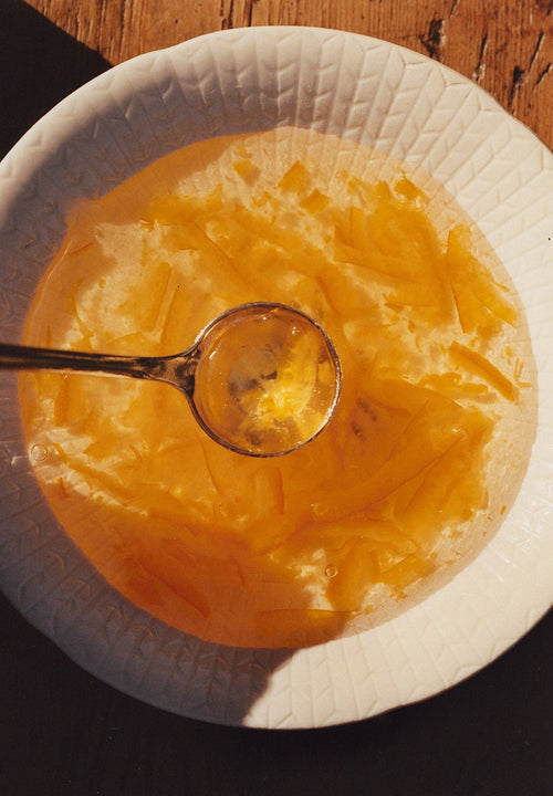 Jar of Sunrise Pixie Tangerine Marmalade by Marmalade Grove showing vibrant orange marmalade spread with visible tangerine pieces.