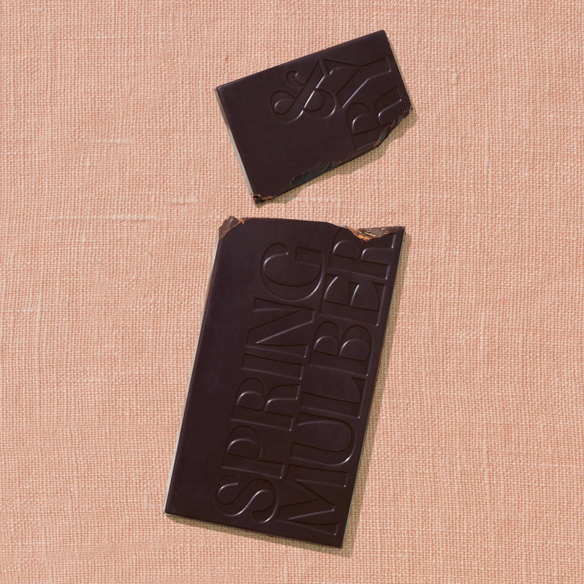 Chocolate bar with 'Spring Nuber' branding on a beige textured surface