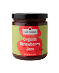 Jar of Clif Family Napa Valley Organic Strawberry Jam with fresh strawberries and natural fruit spread visible in the glass jar.