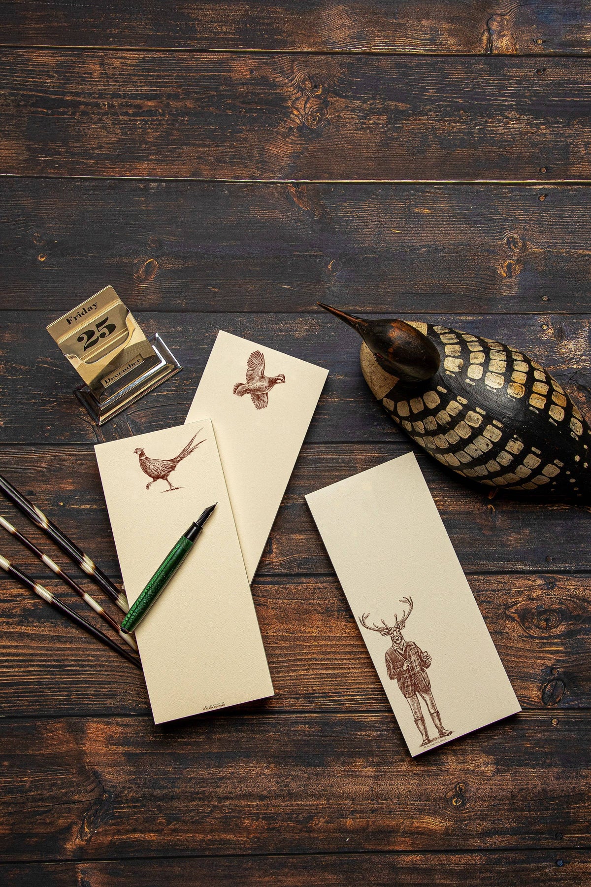 Notebooks with animal illustrations on a wooden surface with a gourd and pencil.