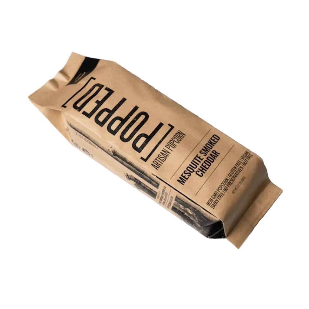 A single pouch of Popped Artisan Popcorn in Masquit Smoke Cheddar flavor, shown at an angle on a clean white background.