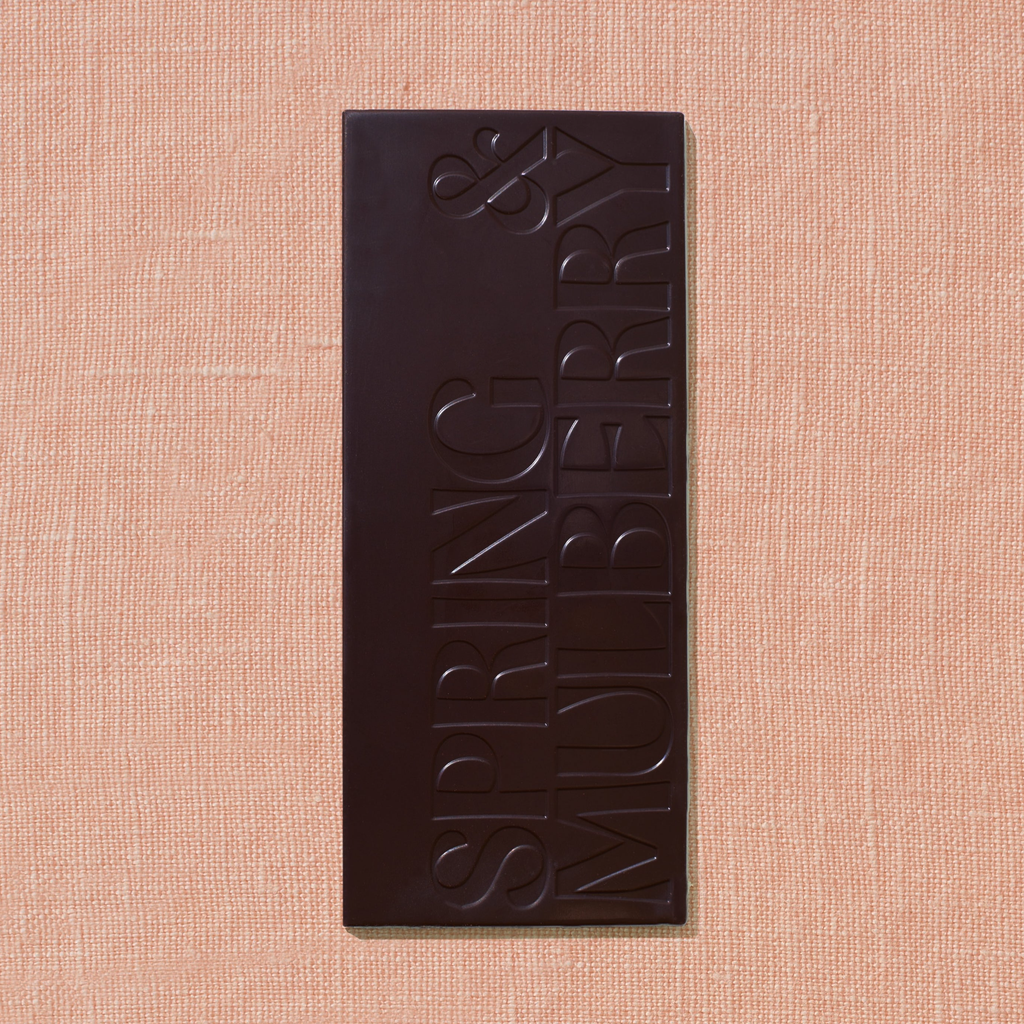 Dark chocolate bar with 'Spring & Mulberry' branding on a beige background