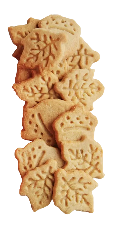 A pile of golden-brown, leaf-shaped sugar cookies on a plain white background.
