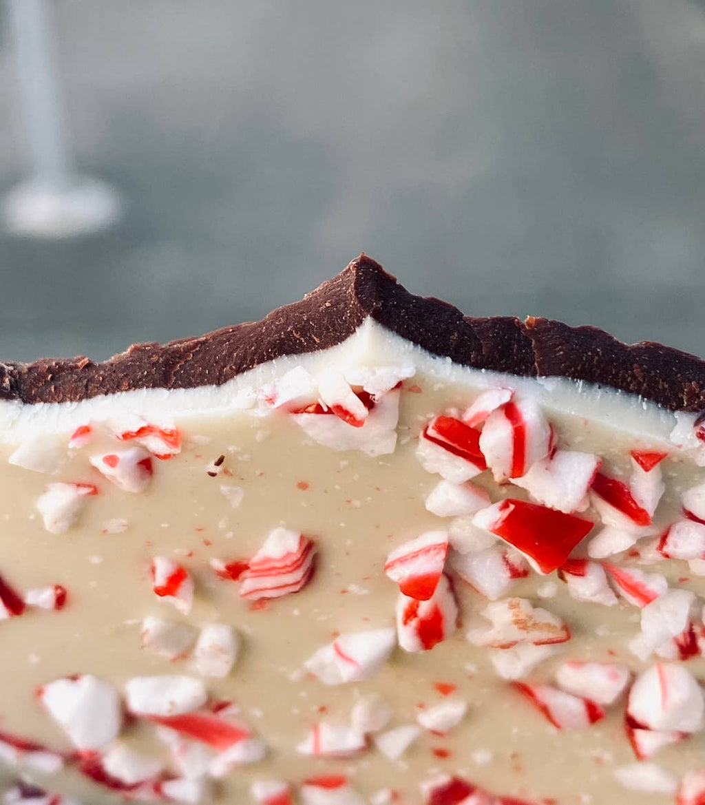 Dick Taylor Peppermint Bark featuring dark and white chocolate with peppermint pieces, packaged in a clear box with a rustic design.