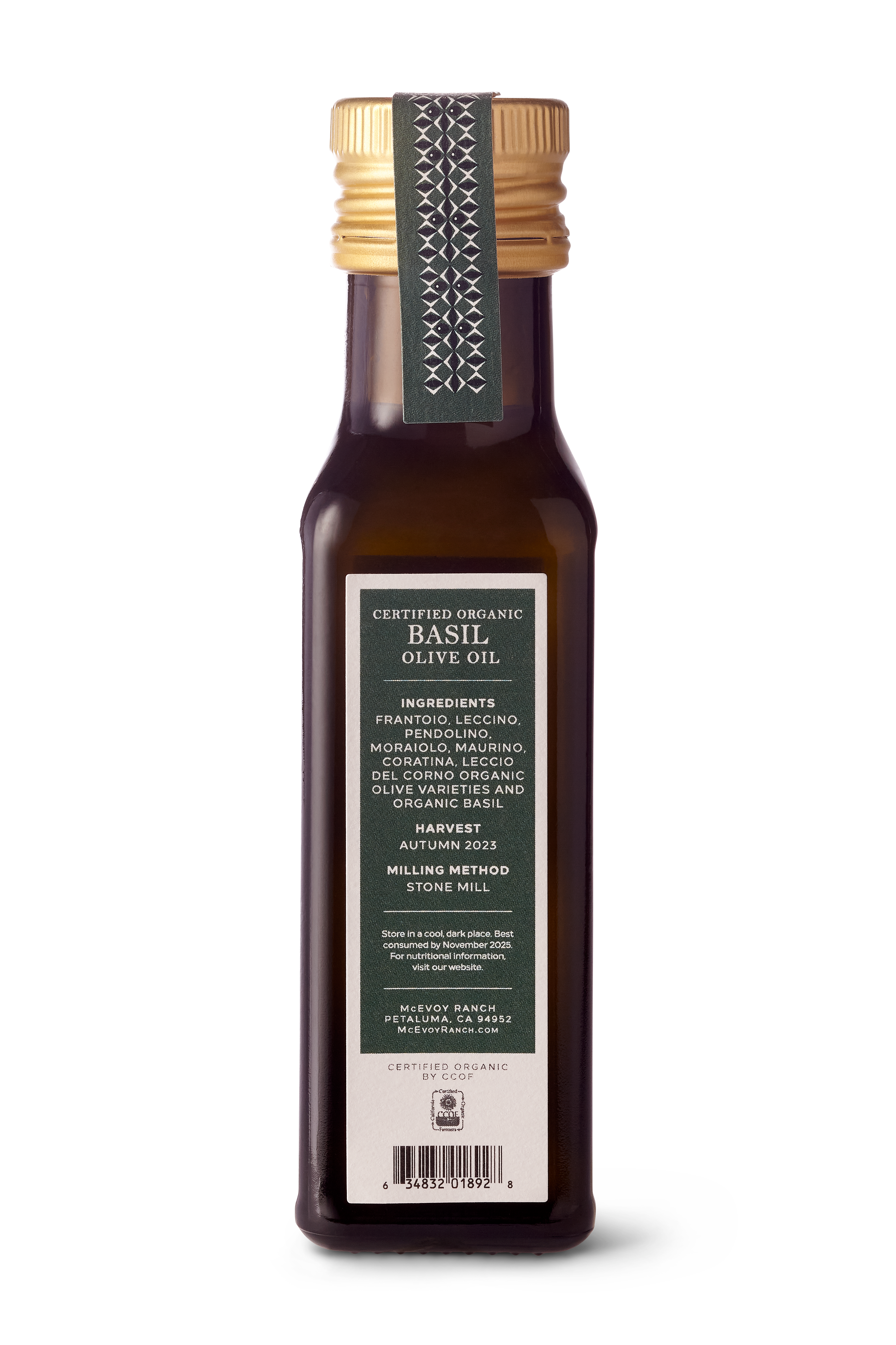 A bottle of Certified Organic Basil Olive Oil from Milling Method, featuring a dark amber glass bottle, a gold screw cap, and a dark green and white label.